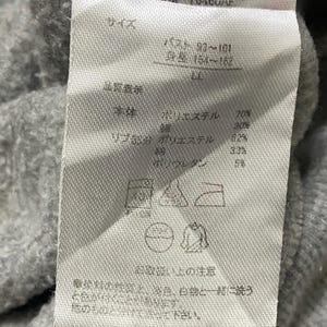 May include: A white tag with black text detailing the size, fabric composition, and care instructions for a grey sweatshirt. The tag includes the text "STGGA14-CL429", "Y6460AF", "バスト 93~101", "身長 154~162", "ポリエステル 70%", "30%", "リブ部分 ポリエステル 62%", "33%", "5%", and "他のものと分けて洗って下さい。"