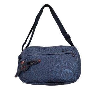 Peut inclure: Sac à bandoulière bleu marine avec un motif léopard. Le sac est doté d'une longue bandoulière réglable et d'un petit porte-clés en forme de singe. Le sac porte l'inscription "Kipling" et un motif d'étoile.
