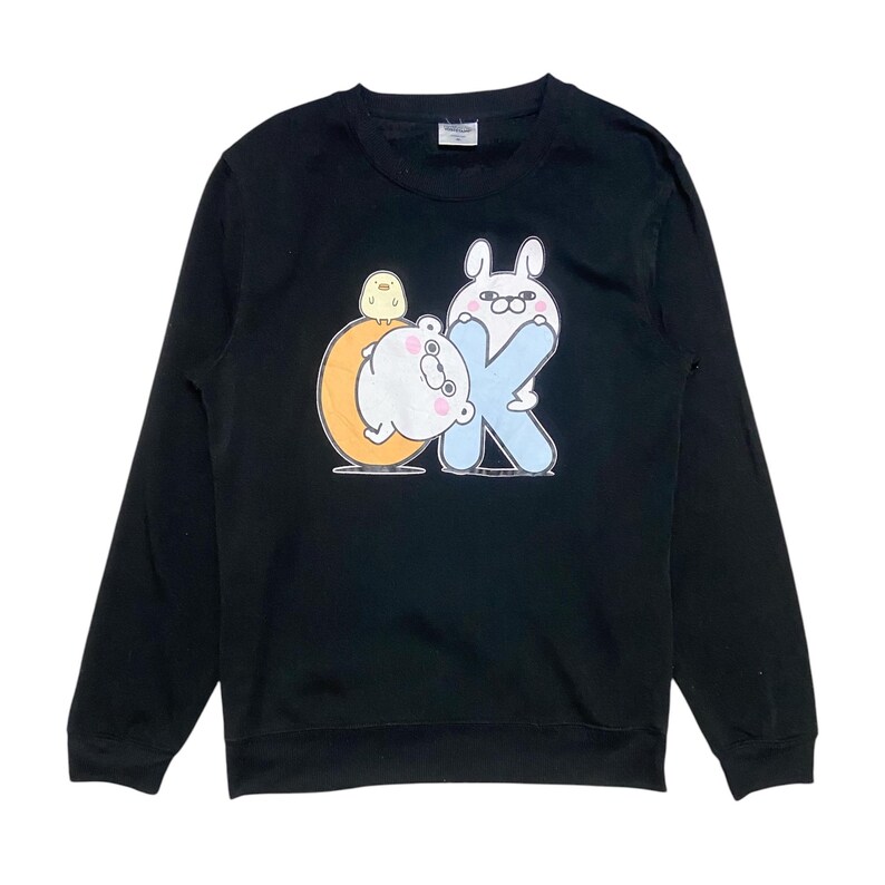 May include: Black long-sleeved sweatshirt with a graphic print of a white bear, a yellow chick, and a pink bunny holding a blue letter K. The graphic says "OK" with the K being the bunny.