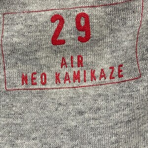 May include: A gray t-shirt with a red rectangular patch that says "29 AIR NEO KAMIKAZE" in white letters.