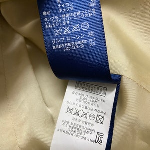 May include: A blue and white care label with washing instructions in both English and Korean. The label includes the text "Ralph Lauren" and "Made in Italy".