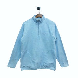 May include: A light blue fleece pullover with a half-zip closure and a small embroidered logo that reads "SUPERIOR FLEECE" on the front.