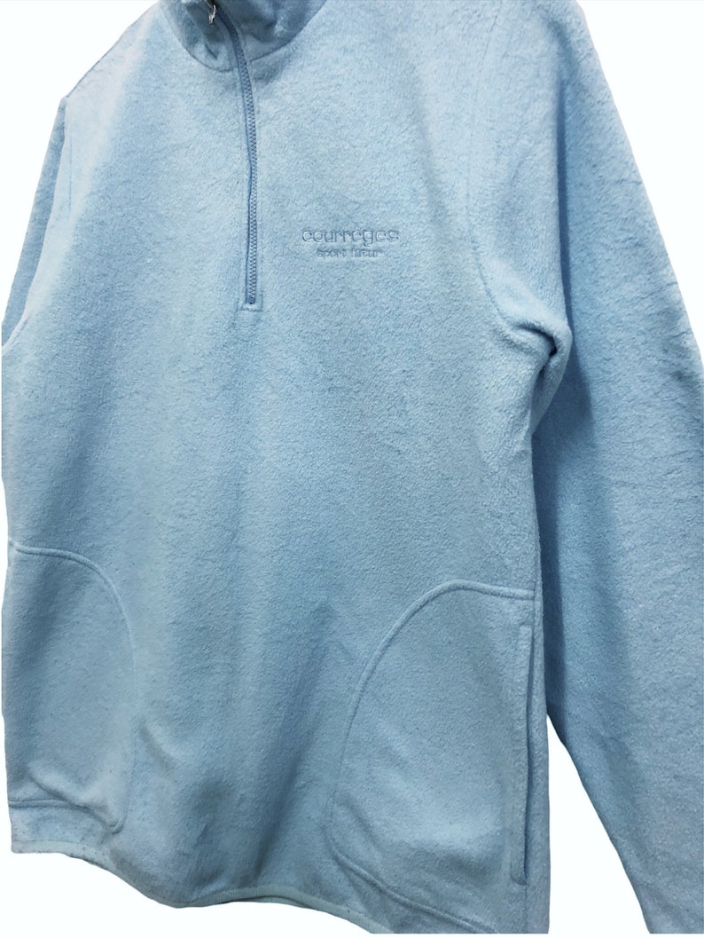 May include: A light blue fleece pullover with a half-zip closure and a small embroidered logo that reads "Country Classics Sport Leisure".