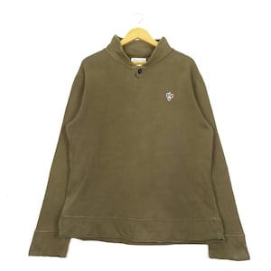May include: A brown, long-sleeved sweatshirt with a mock neck and a single button closure. The sweatshirt has a small, embroidered logo on the chest.