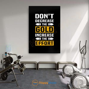 Pode incluir: Um cartaz motivacional com o texto "DON'T DECREASE THE GOLD INCREASE THE EFFORT" em branco e amarelo sobre um fundo preto. O cartaz é exibido em um ambiente de academia com equipamentos de exercício.