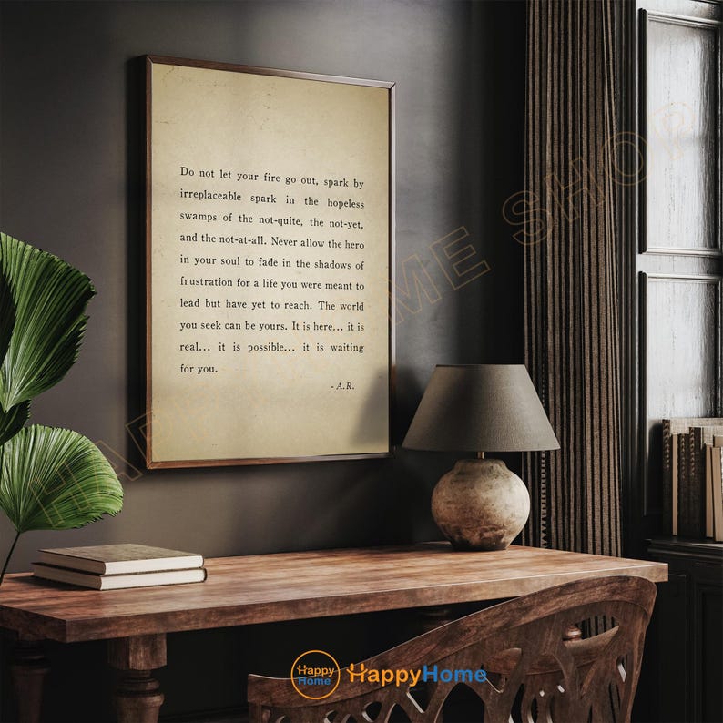 Op de afbeelding: Een ingelijste print met een vintage papieruitstraling, met inspirerende tekst in zwarte letters. De print wordt weergegeven op een houten bureau met een lamp en boeken. De tekst luidt: "Laat je vuur niet doven..."