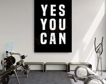 Puede incluir: Un póster motivacional en blanco y negro con el texto "YES YOU CAN" en una fuente desgastada. El póster está colgado en una pared blanca en un gimnasio en casa.