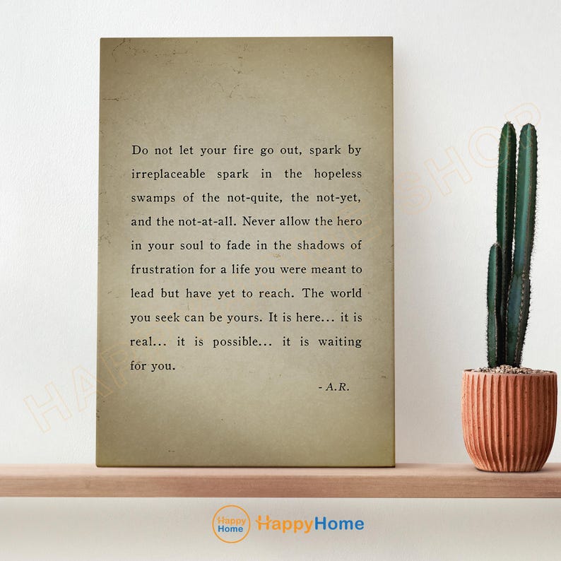 Op de afbeelding: Een ingelijste print met inspirerende tekst op een vintage achtergrond. De tekst luidt: "Laat je vuur niet doven..." en is gesigneerd "- A.R." Een cactus in een terracotta pot staat rechts.