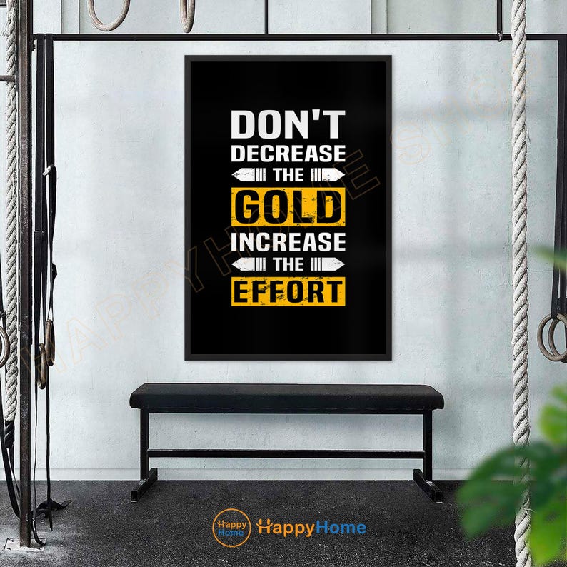May include: A motivational poster with the text "DON'T DECREASE THE GOLD INCREASE THE EFFORT" in white and yellow on a black background. The poster is framed and hangs above a black bench in a gym setting.