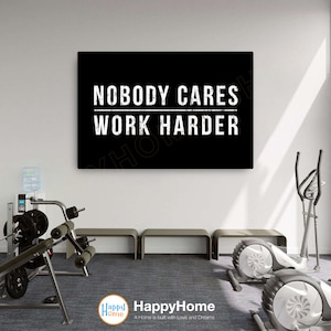 May include: Black and white motivational poster with the text "NOBODY CARES WORK HARDER" in a gym setting with exercise equipment.