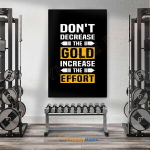 May include: A motivational poster with the text "DON'T DECREASE THE GOLD INCREASE THE EFFORT" in white and yellow on a black background. The poster is displayed in a gym setting, with weightlifting equipment and dumbbells visible.