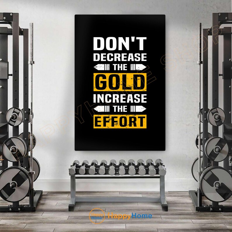 May include: A motivational poster with the text "DON'T DECREASE THE GOLD INCREASE THE EFFORT" in white and yellow on a black background. The poster is displayed in a gym setting, with weightlifting equipment and dumbbells visible.