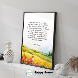 May include: A black framed print with a watercolor background of a field with a quote by Mother Teresa: "You will teach them to fly, but they will not fly your flight. You will teach them to dream, but they will not dream your dream. You will teach them to live, but they will not live your life. Nevertheless, in every flight, in every life, in every dream, the print of the way you taught them will remain."