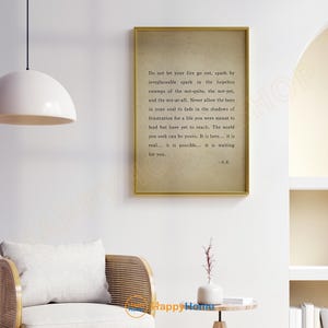 Op de afbeelding: Een ingelijste print met een gouden rand met inspirerende tekst op een beige achtergrond. De tekst bevat de zin "Laat je vuur niet doven..." en is gesigneerd met "-A.R." De print wordt op een witte muur weergegeven.