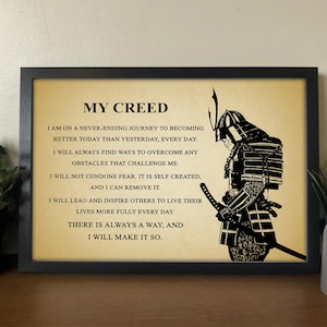 Op de afbeelding: Een zwart-wit afbeelding van een samoerai-krijger met een citaat over persoonlijke groei en leiderschap. Het citaat luidt: "Mijn Credo: Ik ben op een nooit eindigende reis om vandaag beter te worden dan gisteren, elke dag. Ik zal altijd manieren vinden om alle uitdagingen te overwinnen. Ik zal geen angst tolereren. Het is zelf gecre&euml;erd, en ik kan het verwijderen. Ik zal anderen leiden en inspireren om hun leven elke dag voller te leven. Er is altijd een weg, en ik zal hem vinden."
