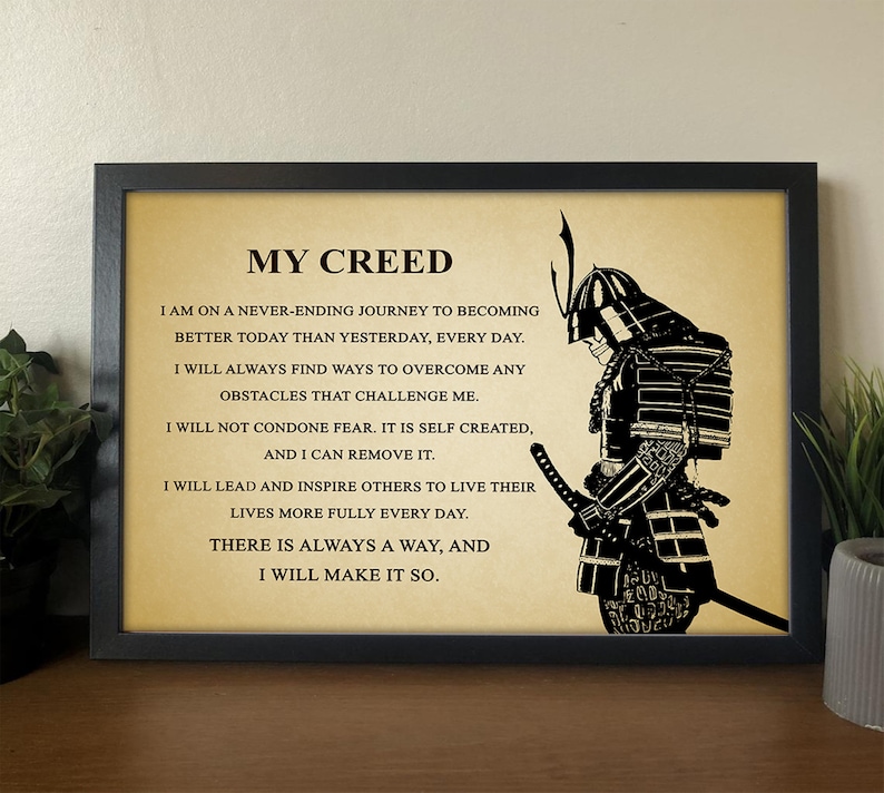 Op de afbeelding: Een zwart-wit afbeelding van een samoerai-krijger met een citaat over persoonlijke groei en leiderschap. Het citaat luidt: "Mijn Credo: Ik ben op een nooit eindigende reis om vandaag beter te worden dan gisteren, elke dag. Ik zal altijd manieren vinden om alle uitdagingen te overwinnen. Ik zal geen angst tolereren. Het is zelf gecre&euml;erd, en ik kan het verwijderen. Ik zal anderen leiden en inspireren om hun leven elke dag voller te leven. Er is altijd een weg, en ik zal hem vinden."