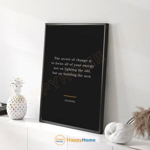 May include: Black and white motivational quote poster with a white background and black text. The quote reads "The secret of change is to focus all of your energy not on fighting the old, but on building the new." The quote is attributed to Socrates.