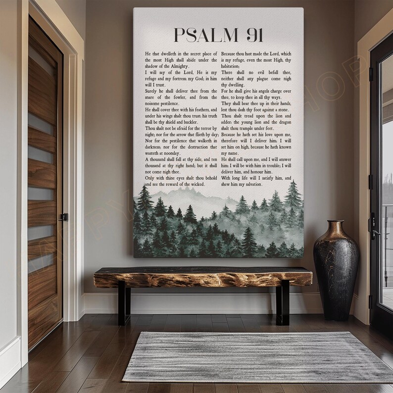 May include: A framed canvas print featuring the text of Psalm 91 in black font. Below the text is a watercolor landscape of a forest and mountains. The print hangs above a wooden bench.