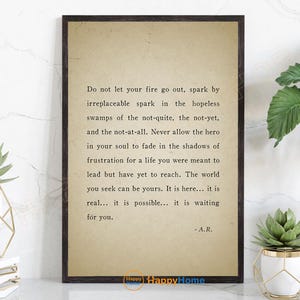 Op de afbeelding: Een ingelijste print met een vintage papieren achtergrond met inspirerende tekst in een klassiek schreeflettertype. Het citaat, toegeschreven aan A.R., moedigt doorzettingsvermogen en zelfvertrouwen aan. De print wordt getoond met decoratieve planten.