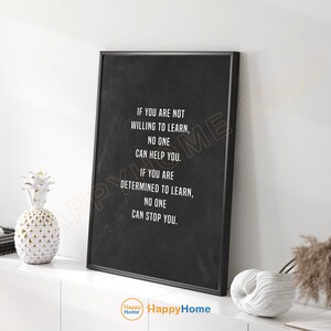Puede incluir: Un póster de cita motivacional enmarcado en negro con texto blanco que dice "Si no estás dispuesto a aprender, nadie puede ayudarte. Si estás decidido a aprender, nadie puede detenerte." El póster está en un estante blanco con una piña blanca y un objeto decorativo blanco.