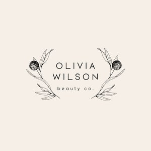 K&ouml;nnte beinhalten: Schwarzwei&szlig;es Logo-Design mit dem Text "Olivia Wilson beauty co." umgeben von stilisierten floralen Zweigen.