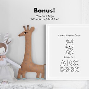 May include: A black and white printable sign with the text "Please Help Us Color Baby's First ABC BOOK". The sign features a cartoon bunny holding a smaller bunny. The sign is framed in a white frame.