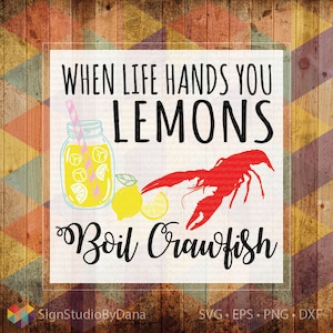 以下が含まれることがあります： 「When life hands you lemons, boil crawfish」と書かれた白い看板。看板には、レモネードが入ったメイソンジャー、レモン、赤いザリガニが描かれている。