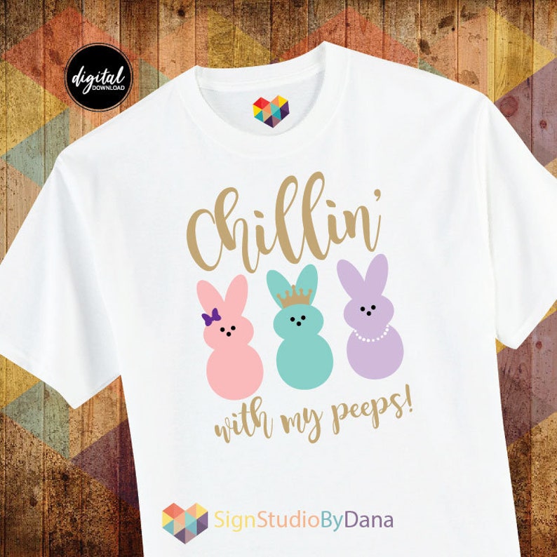 May include: White t-shirt with the text "Chillin' with my peeps!" in gold lettering. Three pastel-coloured Peeps marshmallow bunnies are pictured below the text. The text "SignStudioByDana" is at the bottom of the shirt.
