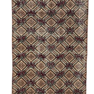 May include: A vintage rug with a geometric pattern in shades of brown, red, and white. The rug has a diamond pattern with a faded look.