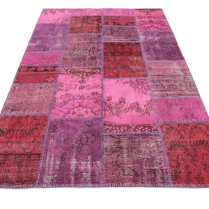 May include: A patchwork rug with a variety of pink and red hues. The rug is made of different pieces of fabric that have been sewn together. The rug has a distressed look, with some of the fabric pieces being faded or worn.