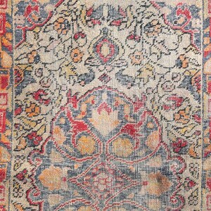 May include: A vintage rug with a faded floral pattern in shades of red, orange, and blue. The rug has a border with a geometric design. The text "URGUP HATIRA" is woven into the rug.
