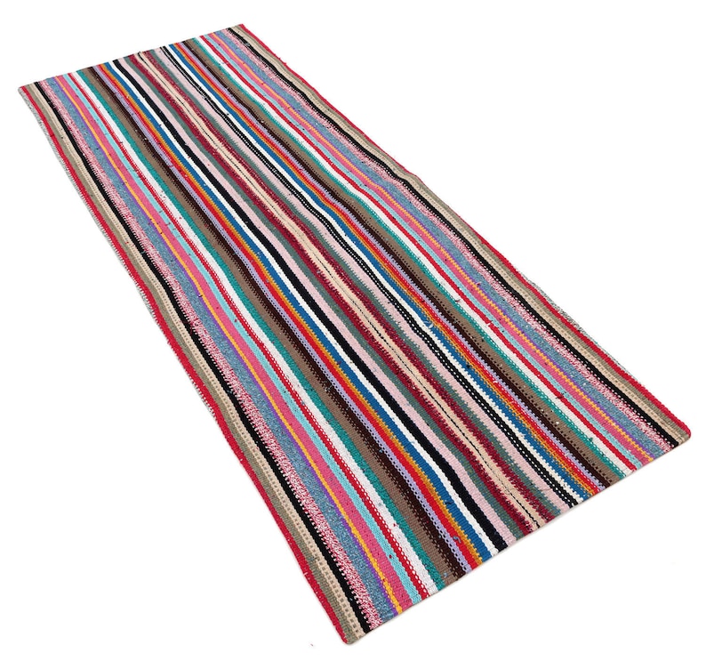May include: A long, narrow, multi-colored striped rug with a variety of colors including pink, blue, red, green, and brown.
