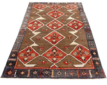 May include: A traditional rug with a brown background and a geometric pattern in shades of red, white, and blue. The rug has a border with a repeating design in shades of blue and black.
