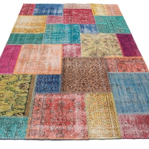 May include: A colorful patchwork rug with a variety of patterns and colors, including blue, green, yellow, red, and brown. The rug is made of recycled materials and has a unique, hand-woven look.