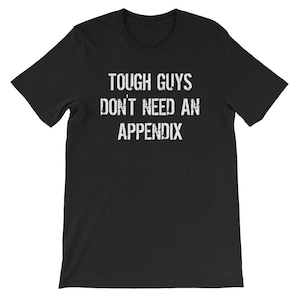 Könnte beinhalten: Schwarzes T-Shirt mit weißem Text, der "Tough Guys Don't Need An Appendix" lautet.