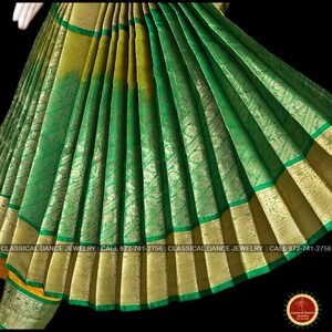 May include: Close-up of a green and gold fabric with intricate patterns. The fabric has a textured appearance with gold borders and accents. The image includes text that reads "CLASSICAL DANCE JEWELRY: CALL 972-741-2756".