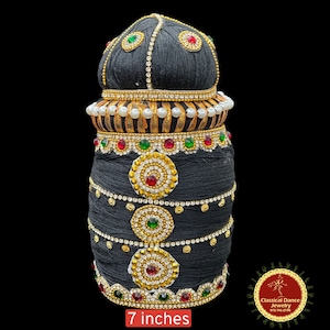 May include: Black hair bun with gold and silver embellishments, red and green jewels, and white pearls. The bun is 7 inches tall.