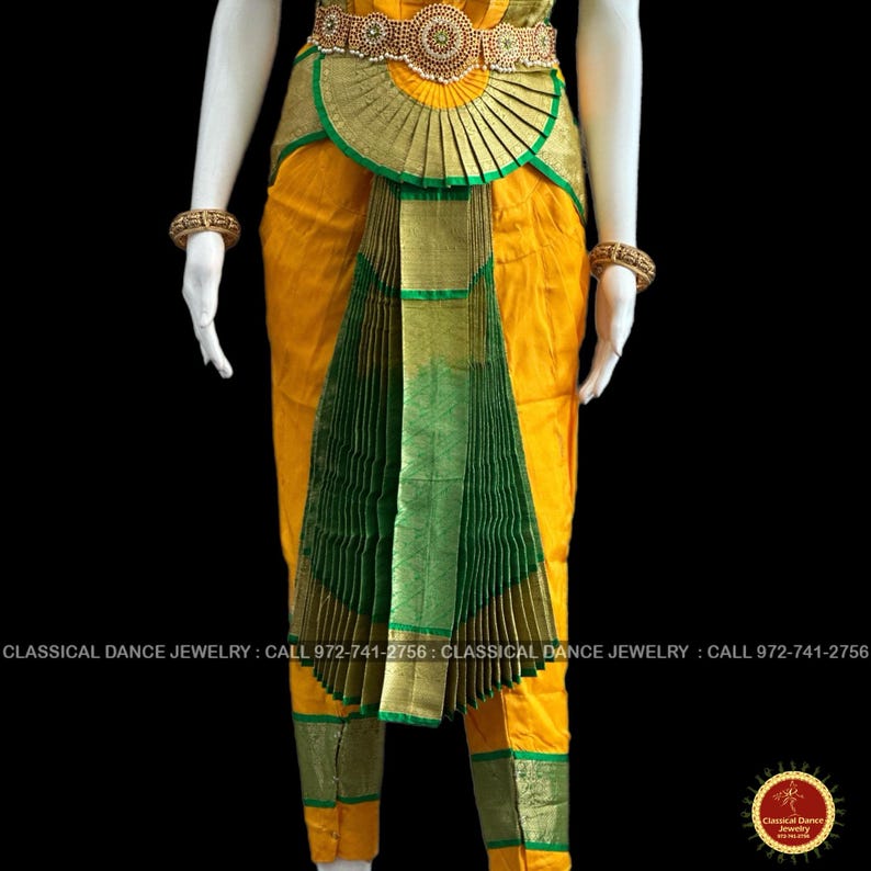 May include: A yellow and green classical dance costume with gold accents. The costume features a pleated green skirt, a gold belt with intricate detailing, and gold trim. The costume is displayed on a mannequin. The text "CLASSICAL DANCE JEWELRY" is visible.