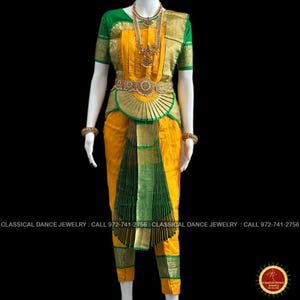 May include: A traditional Indian classical dance costume in yellow and green. The outfit includes a short-sleeved green top, yellow pants, and a decorative belt. Gold jewelry and green and gold accents complete the look. The text on the image says "CLASSICAL DANCE JEWELRY".