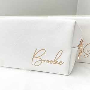May include: White zippered makeup bag with a gold zipper pull and the name "Brooke" written in gold script.