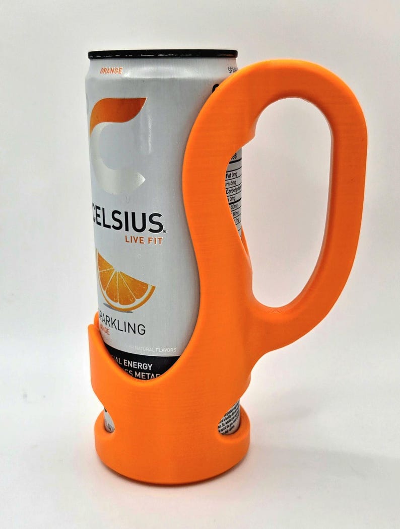 Op de afbeelding: Een oranje 3D-geprinte blikhouder met een handvat, ontworpen om een Celsius Sparkling Orange energiedrankblikje stevig vast te houden. Het blikje is zilverkleurig met oranje en zwarte tekst en afbeeldingen. Het ontwerp van de houder maakt het gemakkelijk om te dragen.