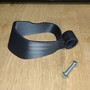 May include: A black plastic 3D printed handle with a screw hole and a silver screw. The handle is designed to be attached to a larger object.
