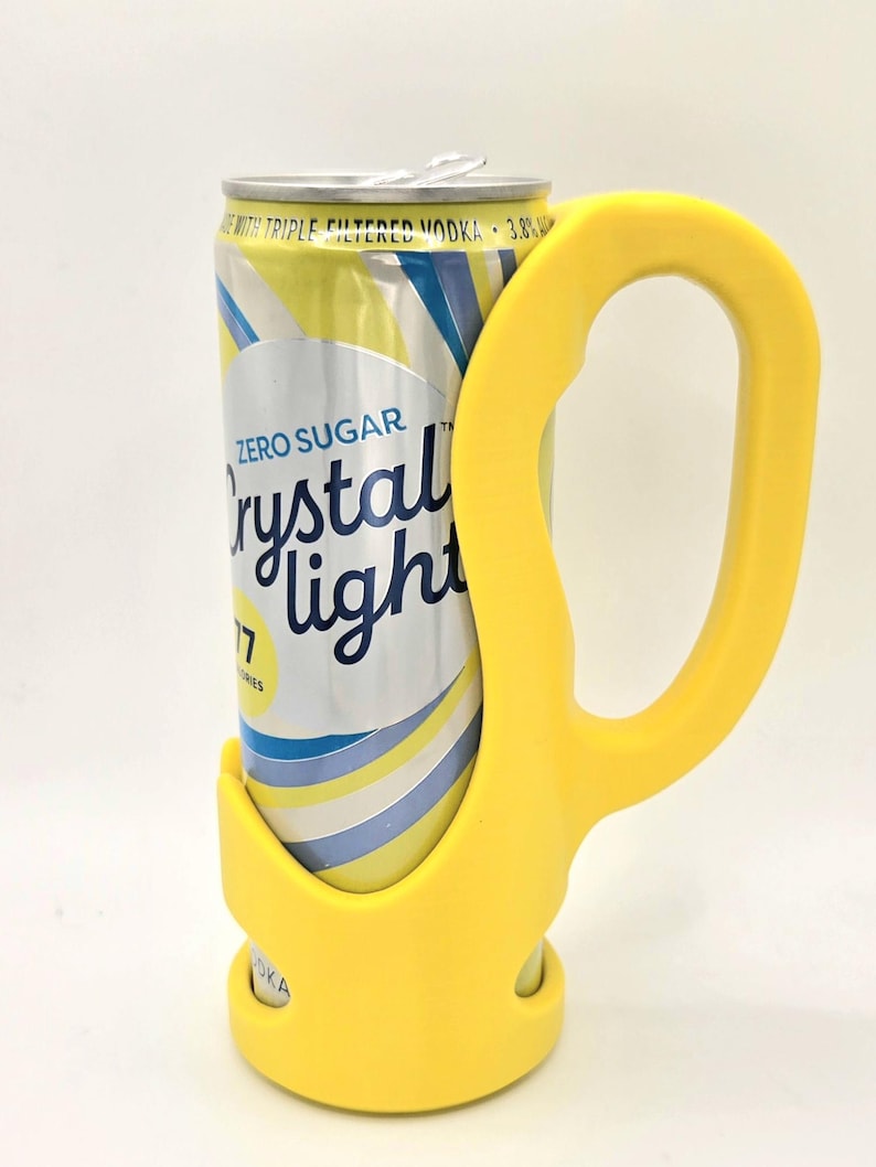 Op de afbeelding: Een gele blikhouder met handvat, ontworpen om een blikje Crystal Light in te houden. Het blikje is zilverkleurig met gele en blauwe strepen en de woorden "Zero Sugar Crystal Light" erop gedrukt. Op het blikje staat ook "with triple filtered vodka 3.8%".