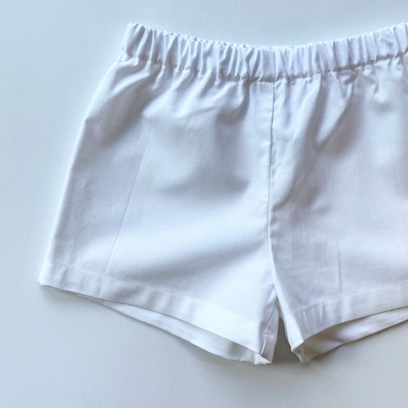 May include: White cotton shorts with an elastic waistband.