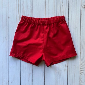 May include: Red cotton shorts with an elastic waistband.