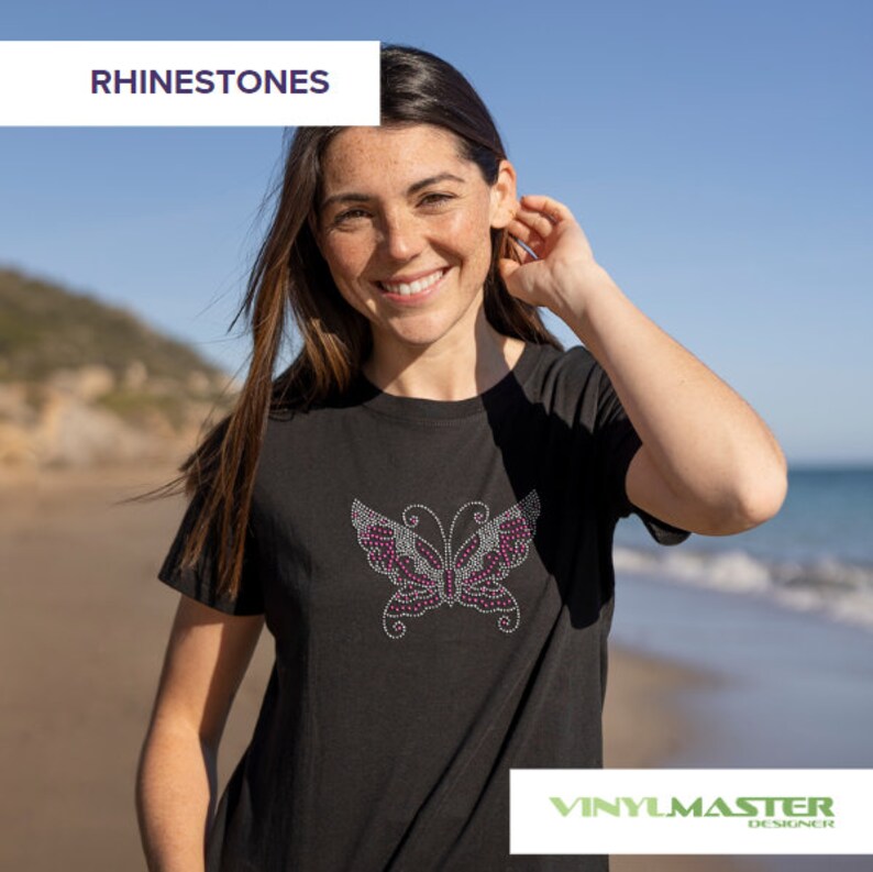 Puede incluir: Una camiseta negra con un dise&ntilde;o de mariposa de brillantes de color rosa. La camiseta la lleva puesta una persona en una playa. El texto "RHINESTONES" est&aacute; en la esquina superior izquierda de la imagen. El texto "VINYLMASTER DESIGNER" est&aacute; en la esquina inferior derecha de la imagen.