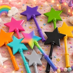 May include: A collection of star-shaped wands in various solid colors including purple, lime green, hot pink, orange, teal, yellow, black, and gray, along with one multicolored gradient star wand, all featuring matching handles and smooth surfaces.
