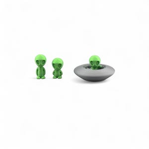 May include: Three green alien figurines, two standing and one in a gray spaceship. The aliens have large oval eyes and small bodies. The spaceship is a simple, round design.