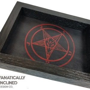 May include: Black wooden dice tray with a red pentagram and a goat's head inside. The tray is made by Fanatically Inclined Design Co.