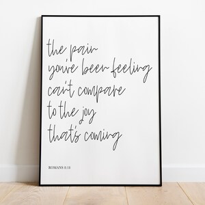 May include: Black and white framed print with the text "the pain you've been feeling can't compare to the joy that's coming" and "ROMANS 8:18" at the bottom.